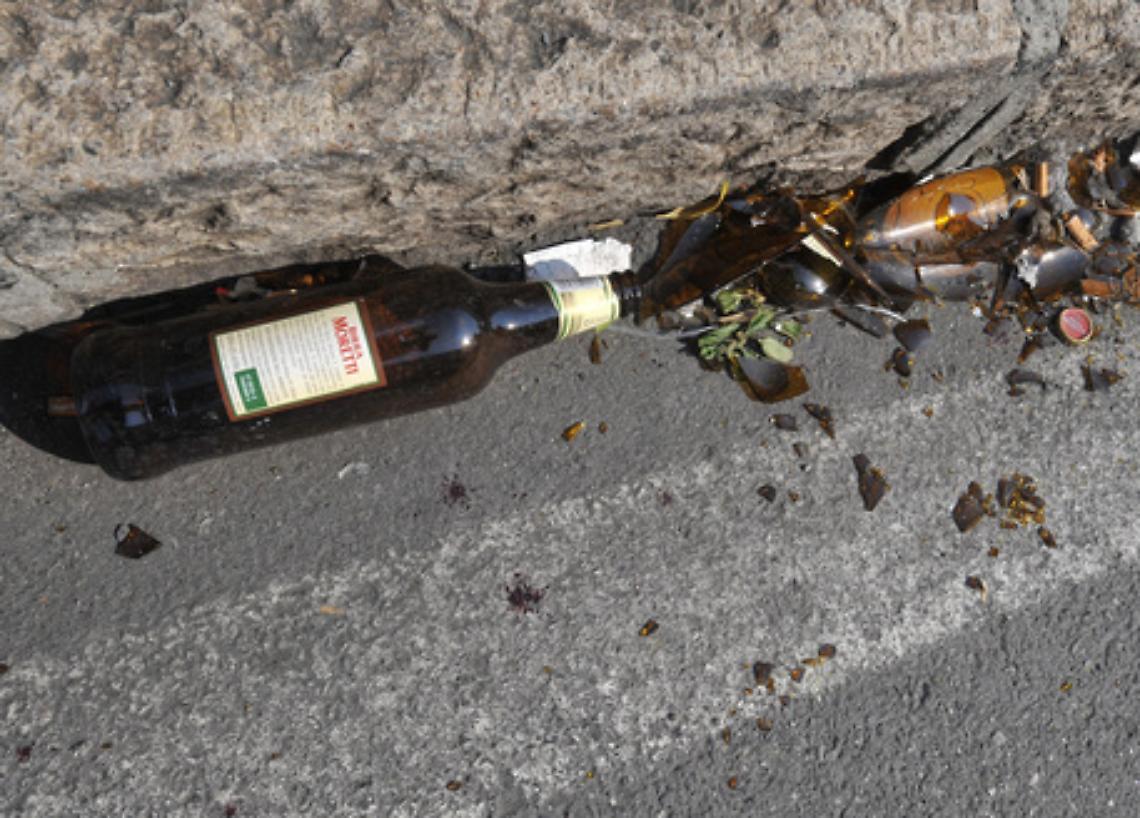 Lancia bottiglie sui passanti e minaccia di suicidarsi