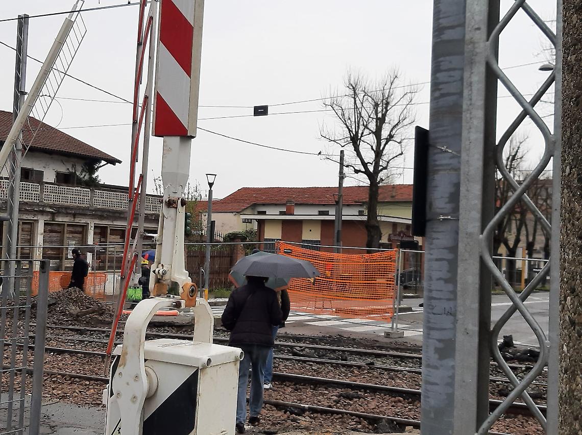 Il passaggio a livello è chiuso ma i pendolari spostano le transenne e attraversano i binari a piedi