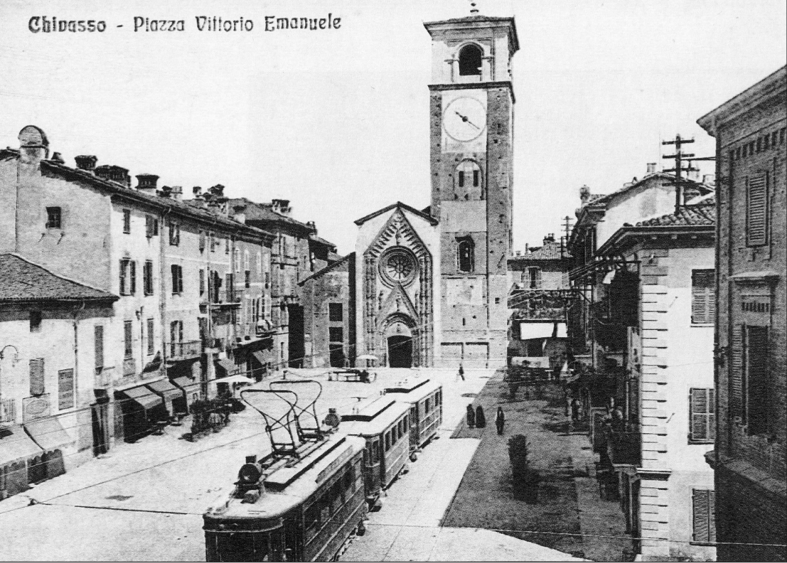 Chivasso, piazza Vittorio Emanuele (ora piazza della Repubblica). Convoglio con motrice e due vetture in sosta. Sullo sfondo appare il Duomo, monumento nazionale del XV secolo