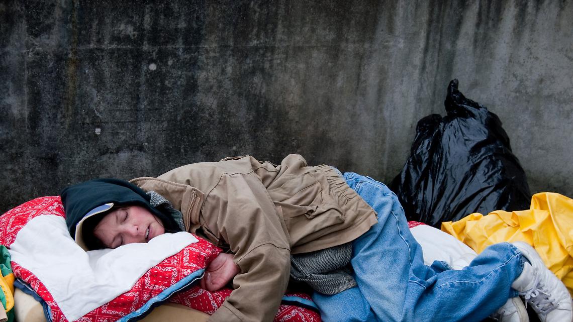 Ivrea, la città che non vede. Una donna dorme su una panchina nell'indifferenza di tutti