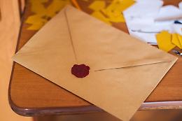 Due bambine imbucano un biglietto di auguri a tutti gli abitanti del paese