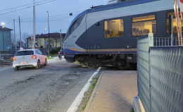 Sbarre del passaggio a livello alzate e treno fermo sulla strada: le macchine gli passano a fianco (VIDEO)