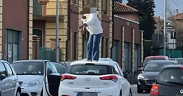 Si spoglia sul tetto dell’auto in mezzo alla strada: traffico in tilt e panico davanti al bar
