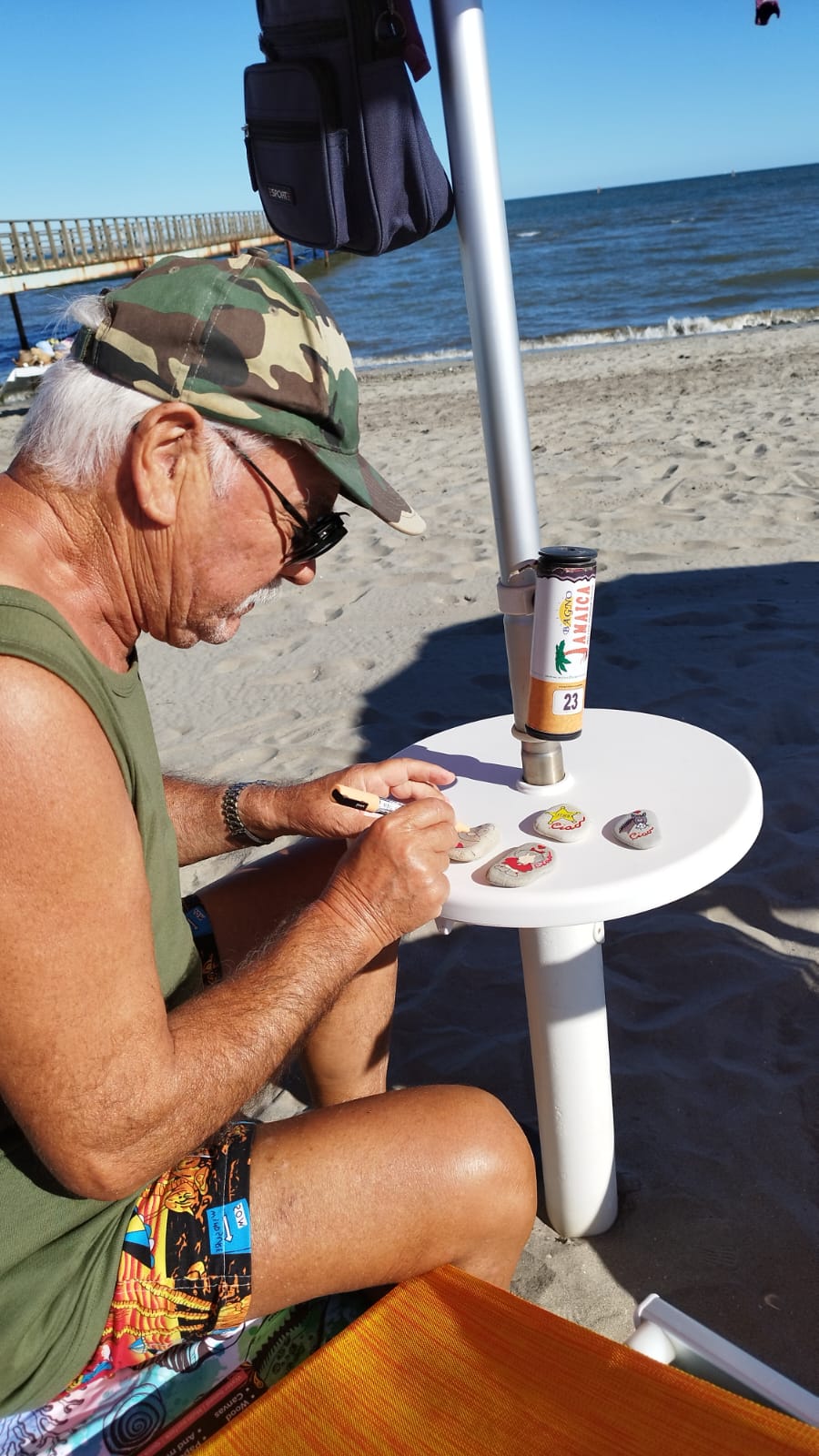 Alberto mentre dipinge i sassi al mare