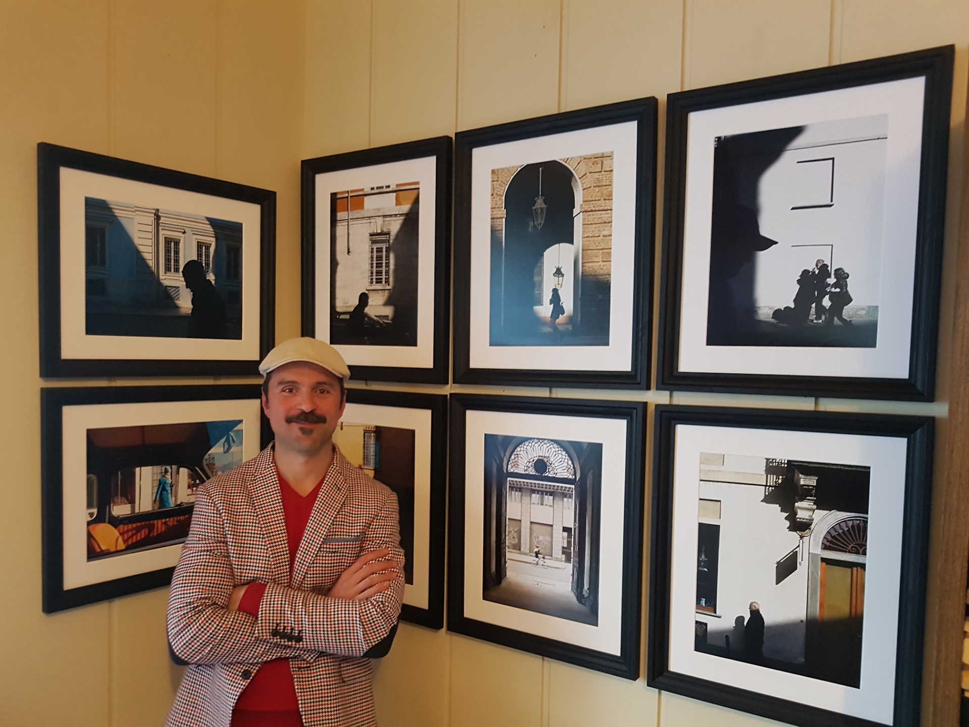 Marco Verlengia con, alle spalle, alcune delle sue fotografie 