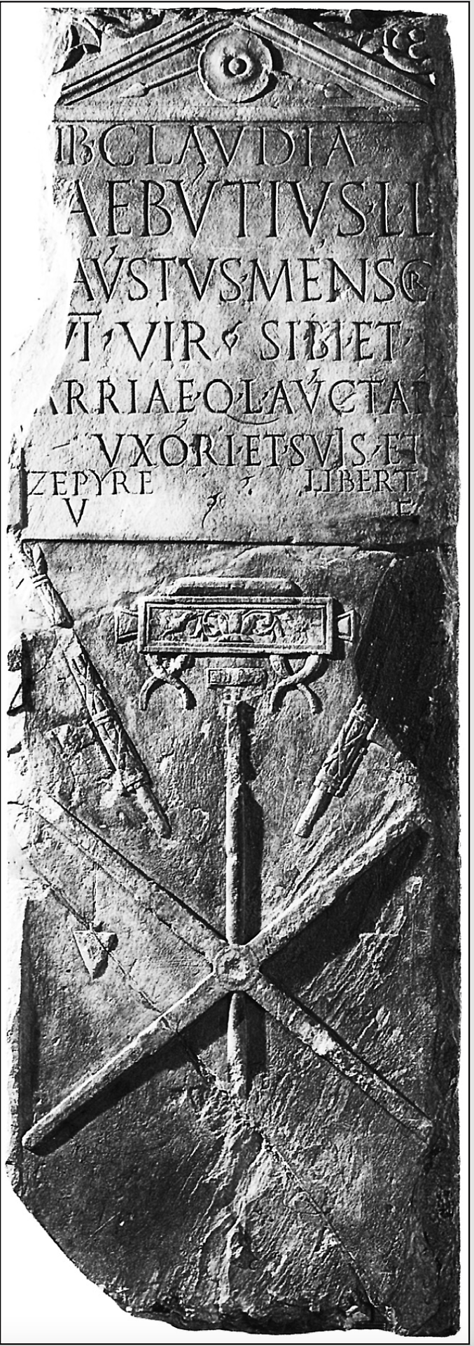 La stele romana intitolata al mensor Lucius Aebutius Faustus, conservata al Museo Garda di Ivrea. In basso è raffigurata la groma, suo strumento di lavoro.