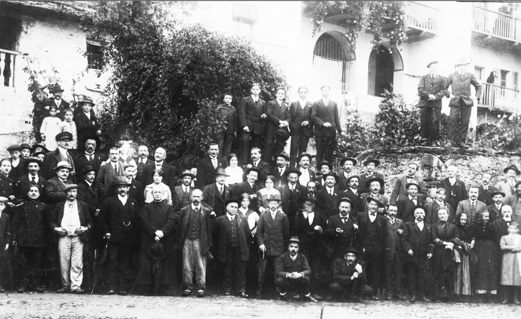 La popolazione di Drusacco, in bella posa, si stringe intorno al parroco don Cavallo davanti alla tera dal furn nel 1906