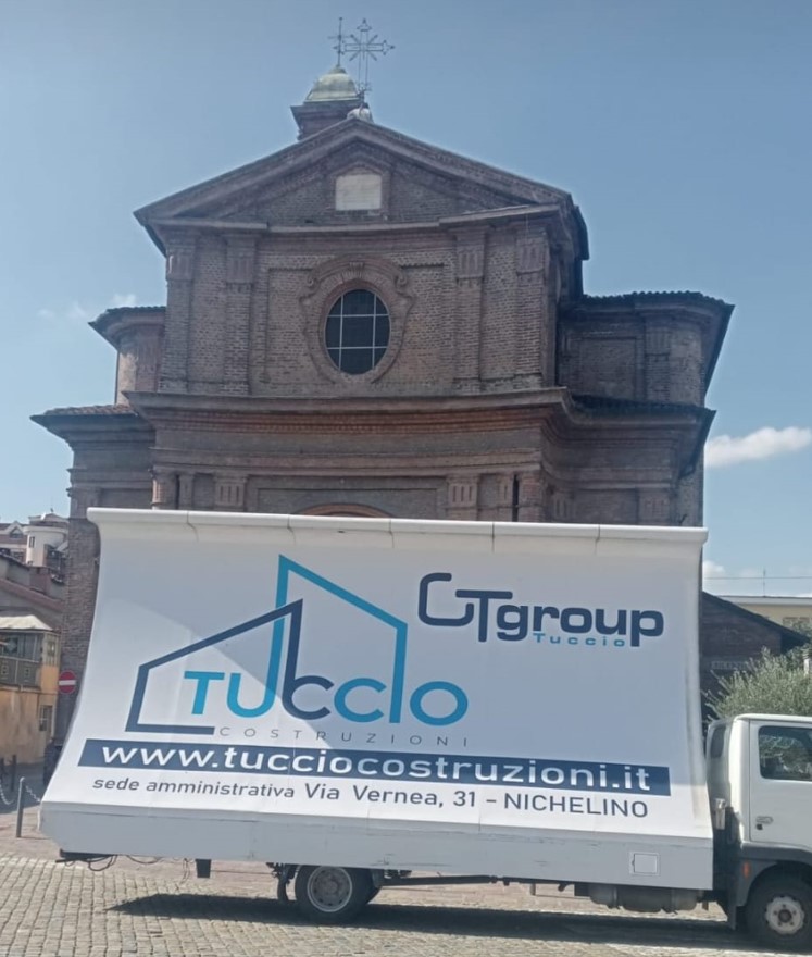 UNO DEI CAMION VELA DELLA ‘TUCCIO COSTRUZIONI SRL’ INNANZI LA CHIESA PARROCCHIALE ANTICA DI NICHELINO DAVANTI PIAZZA G. DI VITTORIO IN CUI SI SVOLGE LA FIERA DI SAN MATTEO