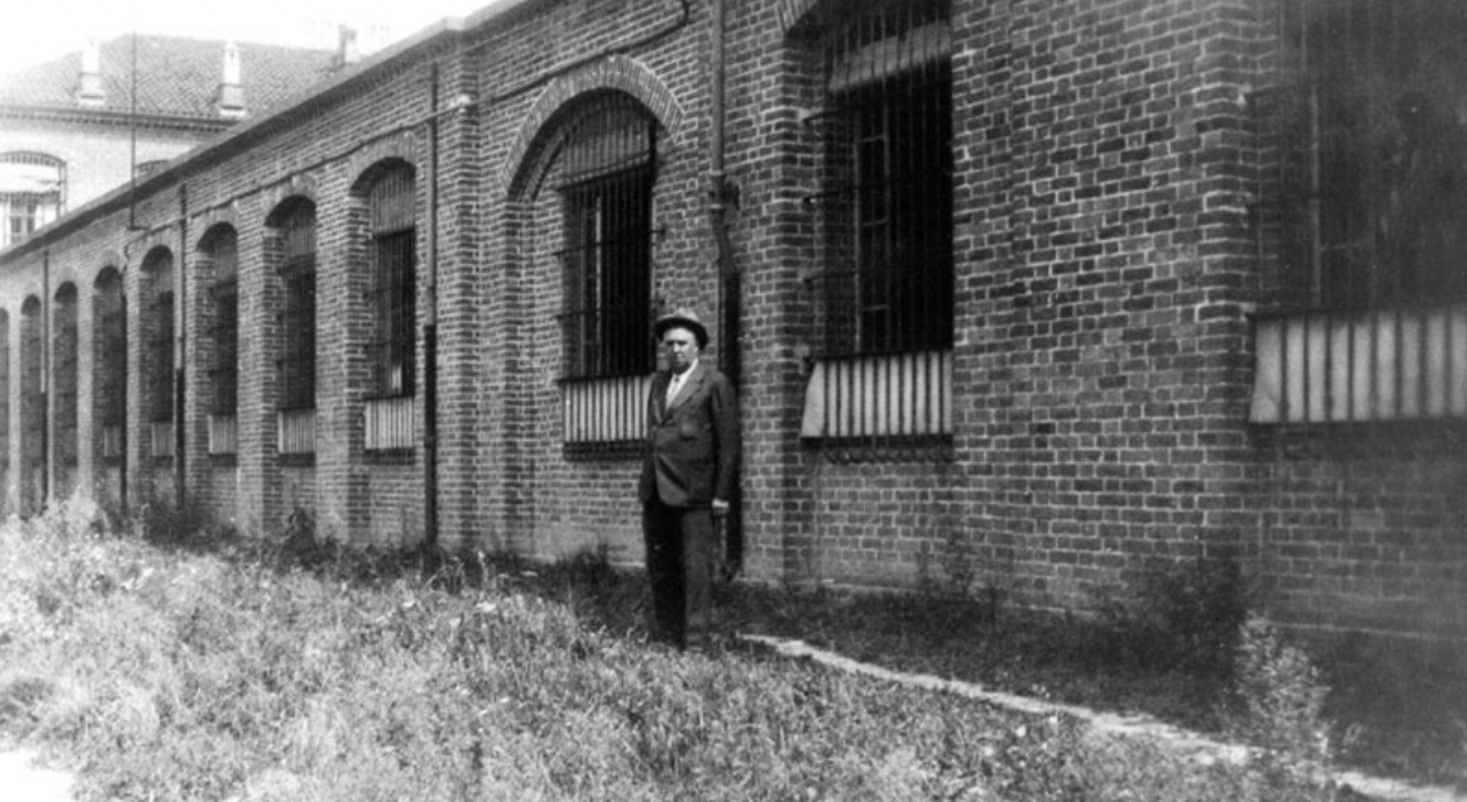 Domenico Burzio (1876-1932), primo Direttore Tecnico della Olivetti, ritratto di fronte alla vecchia sede della fabbrica di Ivrea negli anni '20.